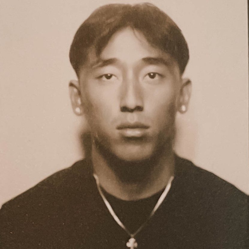 Photobooth portrait of Norbu wearing a cross necklace